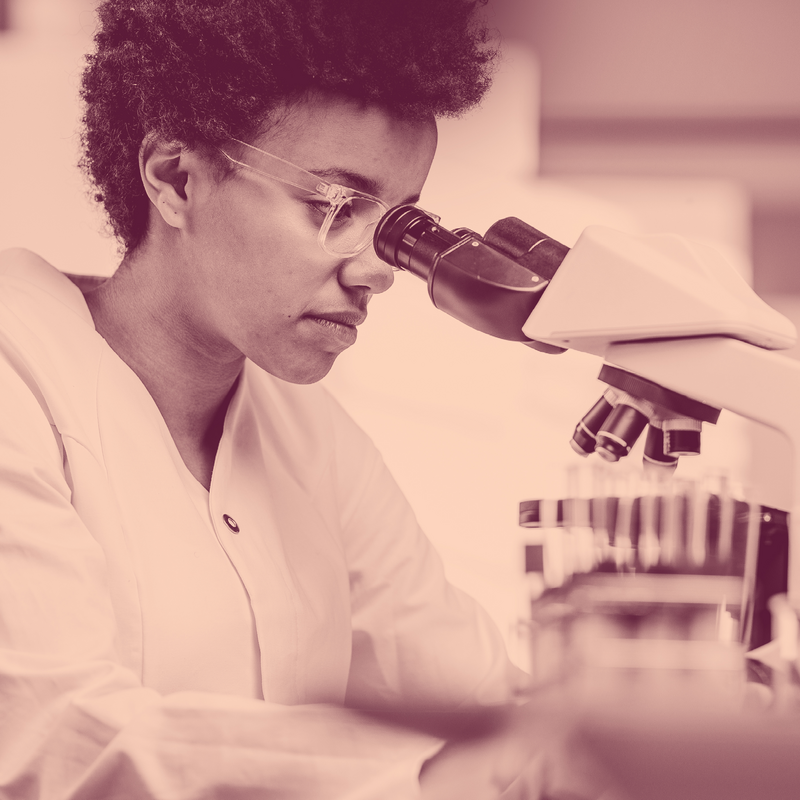 A woman looking through a microscope