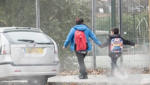 Parent and child next to road with pollution