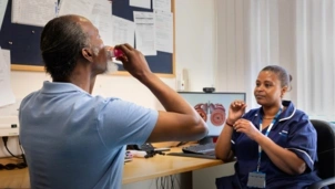 Man using an inhaler with a health care professional