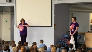 A woman giving a presentation in front of children