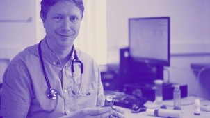 A doctor with a stethoscope sitting in his office