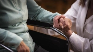 A nurse holding an old person's hand