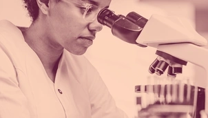 A woman looking through a microscope