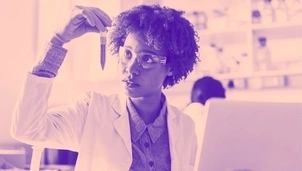 A woman looking at a tube in a lab