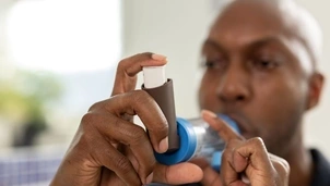 A person using an inhaler with a spacer