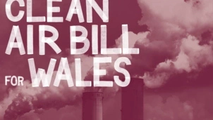 White text reading CLEAN AIR BILL FOR WALES over a maroon-tinted background of industrial chimneys emitting thick smoke