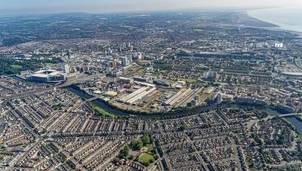 An aerial view of a city with a river running through it, showing a mix of residential, commercial, and industrial areas
