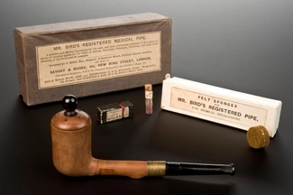 A vintage medical inhalation pipe set, including Mr. Bird's Registered Medical Pipe, felt sponges, and medicinal containers for treating respiratory conditions