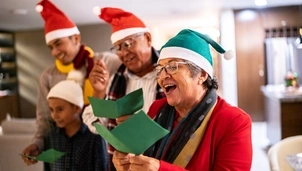 Family singing Christmas carols inside