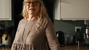 Image of woman standing beside table