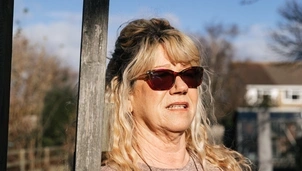 Woman with sunglasses standing in allotment