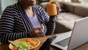 Woman with a mug speaking over Zoom on a laptop