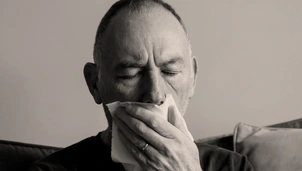 Image of man sneezing
